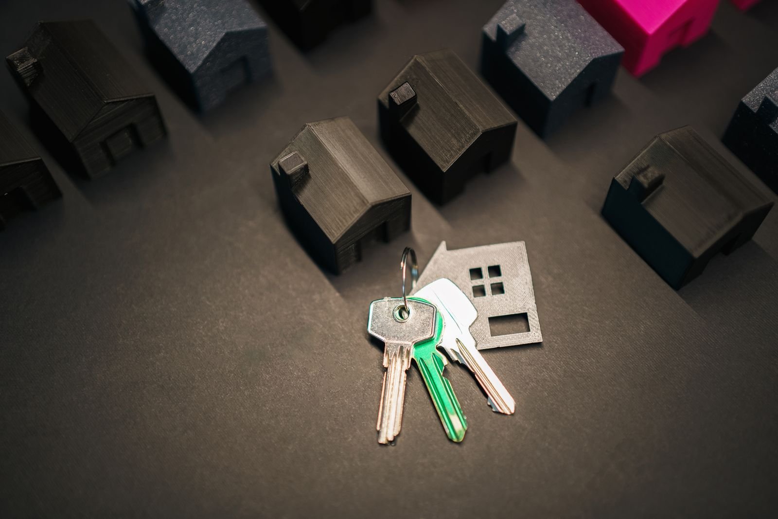 House keys beside a miniature house model